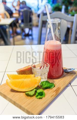 Fresh watermelon smoothie in the glass serve with lemon Basil leaf and passion fruit Selective focus on the front glass