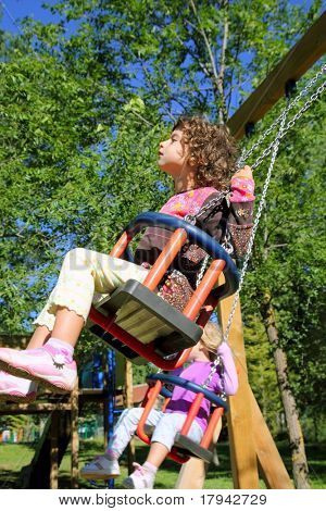 Girl swinging auf Schaukel glücklich in Bäume draußen bis hoch