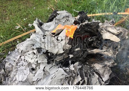 Burning Silver and gold paper and hat to worship ancestor in Chinese culture, the Qingming Festival at graveyard Cemetery
