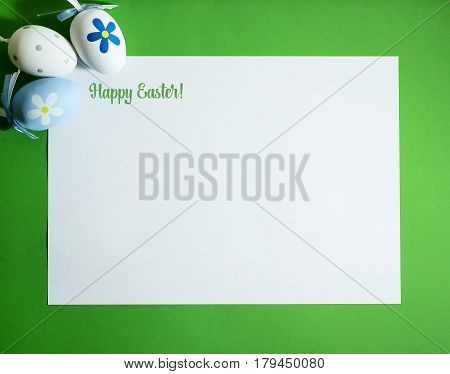 Easter composition with colorful eggs on a green background with copy space