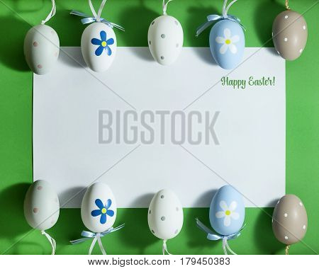 Easter composition with colorful eggs on a green background with copy space