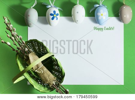 Easter composition with colorful eggs on a green background with copy space