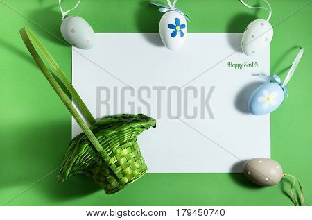 Easter composition with colorful eggs on a green background with copy space