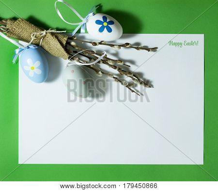 Easter composition with colorful eggs on a green background with copy space