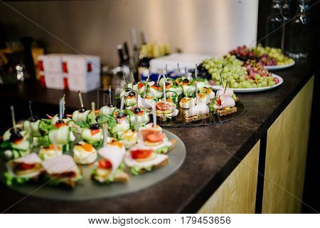 Canape with ham tomato and cucumber on the bar