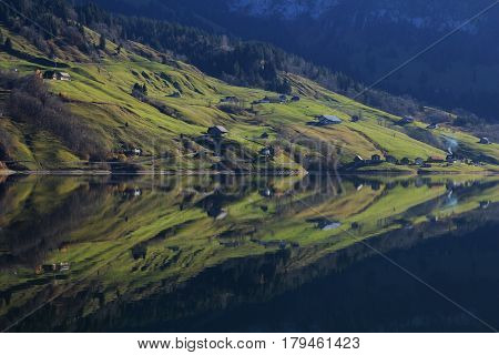 Rural landscape reflecting in lake Wagital Switzerland.