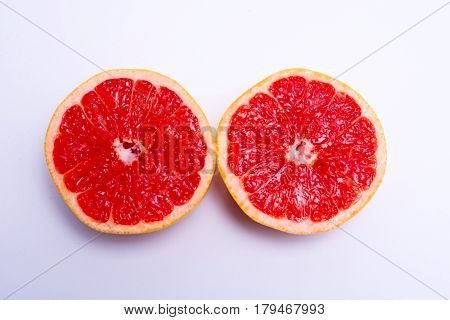Two Fresh Red Grapefruit Halves On White Background