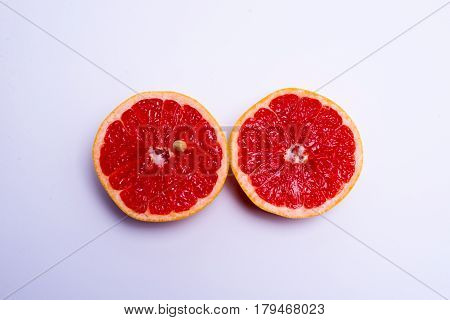 Two Fresh Red Grapefruit Halves On White Background