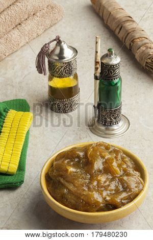 Traditional bowl with Moroccan black argan soap,toothbrush, bottle with kohl and oil in hammam
