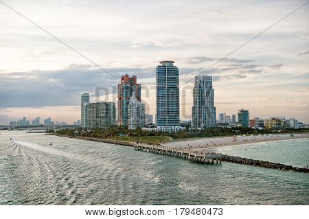 South Miami Beach. Miami skyscrapers with blue cloudy skywhite boat sailing next to Miami downtown Aerial view
