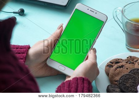 Beautiful girl holding a smartphone in the hands of a green screen green screen, hand of man holding mobile smart phone with chroma key green screen on white background, new technology concept