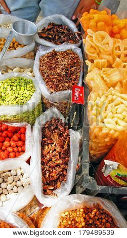 Mexican tradional snack sold by local stall in Mexico. There are fried grasshoppers(chapulines) with chili or garlic, peanut, pistachio nuts, fried peas and cookies.