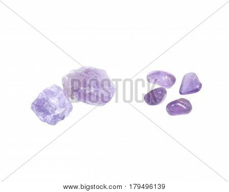Amethyst: natural chunks from Madagascar and tumbled stones from Brazil isolated on white background