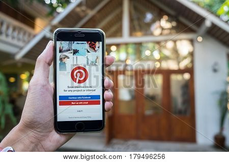CHIANG MAI THAILAND - JAN 202017: A man holds Apple iPhone with Pinterest application on the screen. Pinterest is an online pinboard that allows people to pin their interesting things.