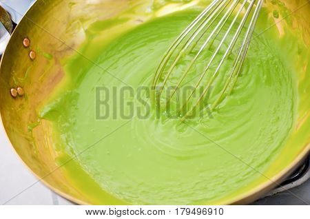 Putting The Ingredint Into A Brass Pan For Cooking A Bakery