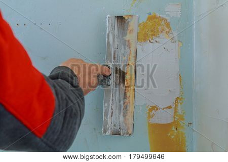 Male builder makes repairs in the apartment plaster trowel tools