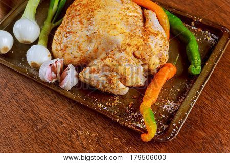 Whole raw chicken seasoned with butter and herbs for roasting. Top view, vintage toned image RAW marinated whole chicken cook