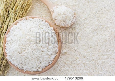 White rice in bowl and a bag a wooden spoon and rice plant on white rice background Top view with copy space