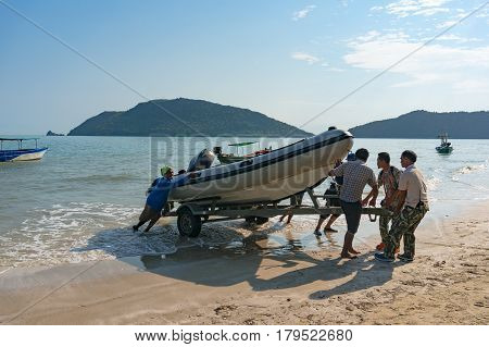 People Pulling Boat On Shore