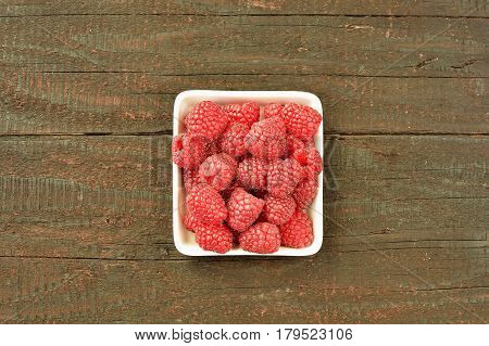 Raspberry fruit on wood background. Forest fruit in white idaeus. Delicious fresh berries.