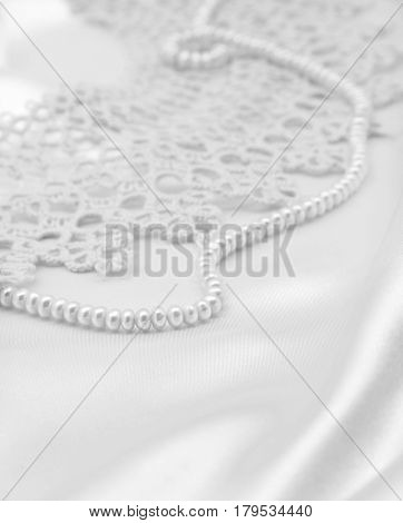 Smooth elegant white silk or satin with pearls and lace can use as wedding background. In black and white toned. Retro style