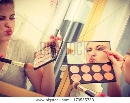 Woman In Bathroom Applying Contour Bronzer On Brush
