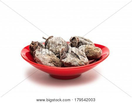 Dried persimmon fruits in red ceramic vase. Oriental sweets