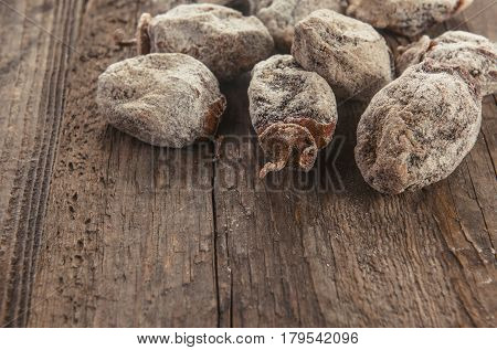 Dried persimmon fruits on wooden background. Oriental sweets