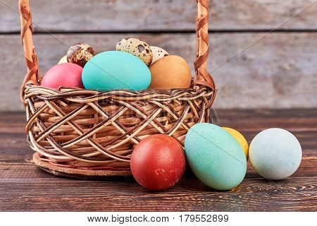 Easter basket on brown wood. Dyed chicken eggs. How to paint eggs.