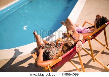 Beautiful appy girls smiling by the pool and enjoying summer