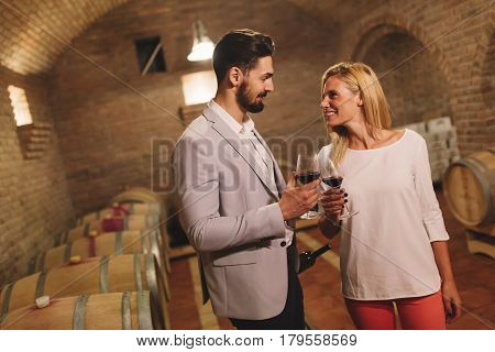 Wine loving couple tasting wines in winery cellar