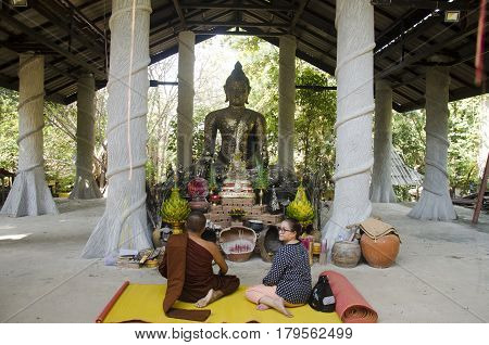 Thai Old Woman Pray Flower And Burning Incense At Thurible For Respect With Buddha Statue And Monk A