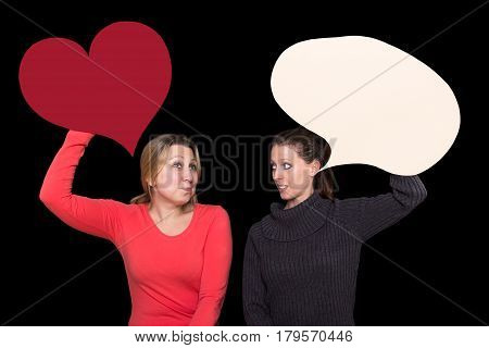 Two young women talking and holding a heart and a speech bubble up