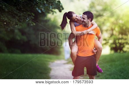 Happy sporty couple hacing fun after jogging in nature