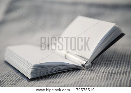 White opened notebook on a material background