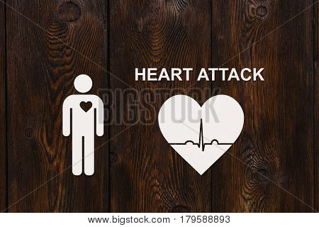 Paper man with echocardiogram and HEART ATTACK text. Medical cardiology concept