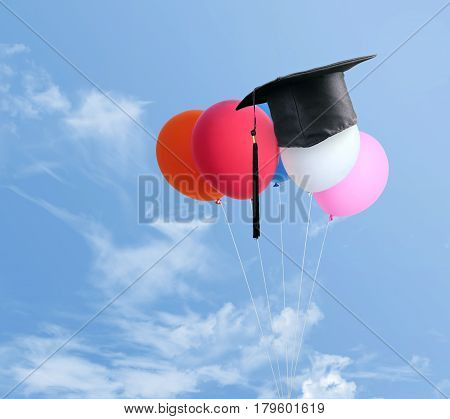 Congratulations Graduates On Top Of Balloons With Blue Sky Background.