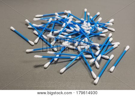 Spilled blue cotton swabs on wooden background