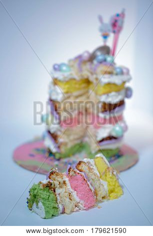 Naked cake with five layers in different flavor and small eggs chocolate attached to it in different color.