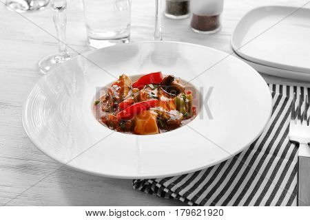 Plate with tasty chicken cacciatore on table