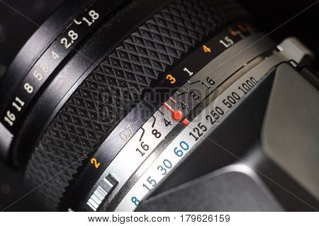 Old film camera lens with depth of field scale and focus ring