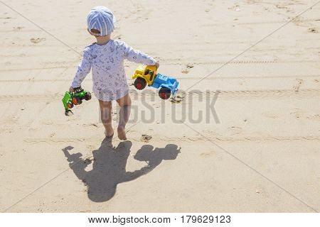 Baby boy walking with toys at the beach. El Rompido Cartaya Huelva Spain