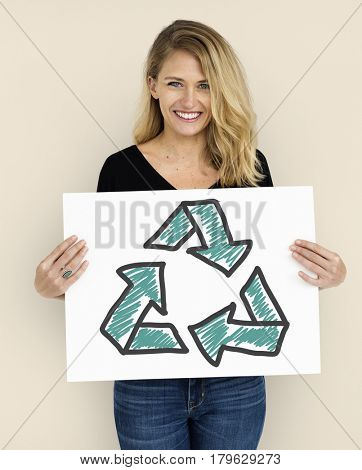 Woman holding placard with recycle sign