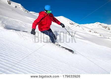 Man Skiing On The Prepared Slope With Fresh New Powder Snow In Alps