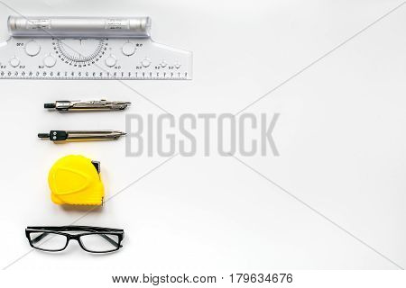 architect working desk with glasses, compass, tape-line and ruler on white background top view mock up