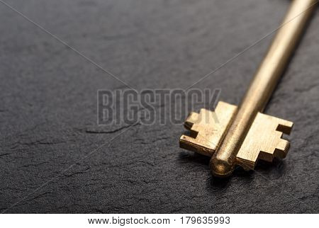 Golden metal key on a black background horizontal photo