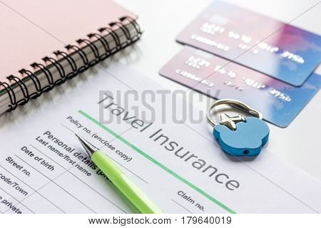 Travel insurance application form with credit cards on white desk background