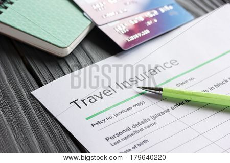 Travel preparation concept with insurance application form and credit cards for online payment on wooden table background