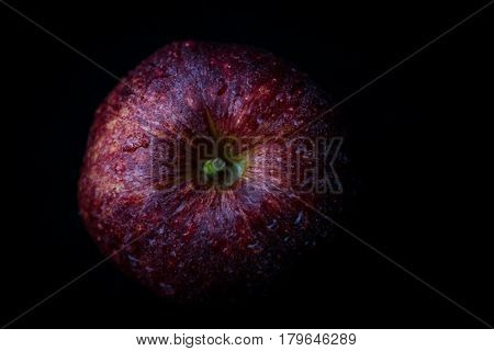 Close up of red apple against black background. View from above