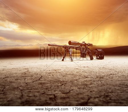 The Rifle Lies On The Dry Desert Ground With A Beautiful Orange Background
